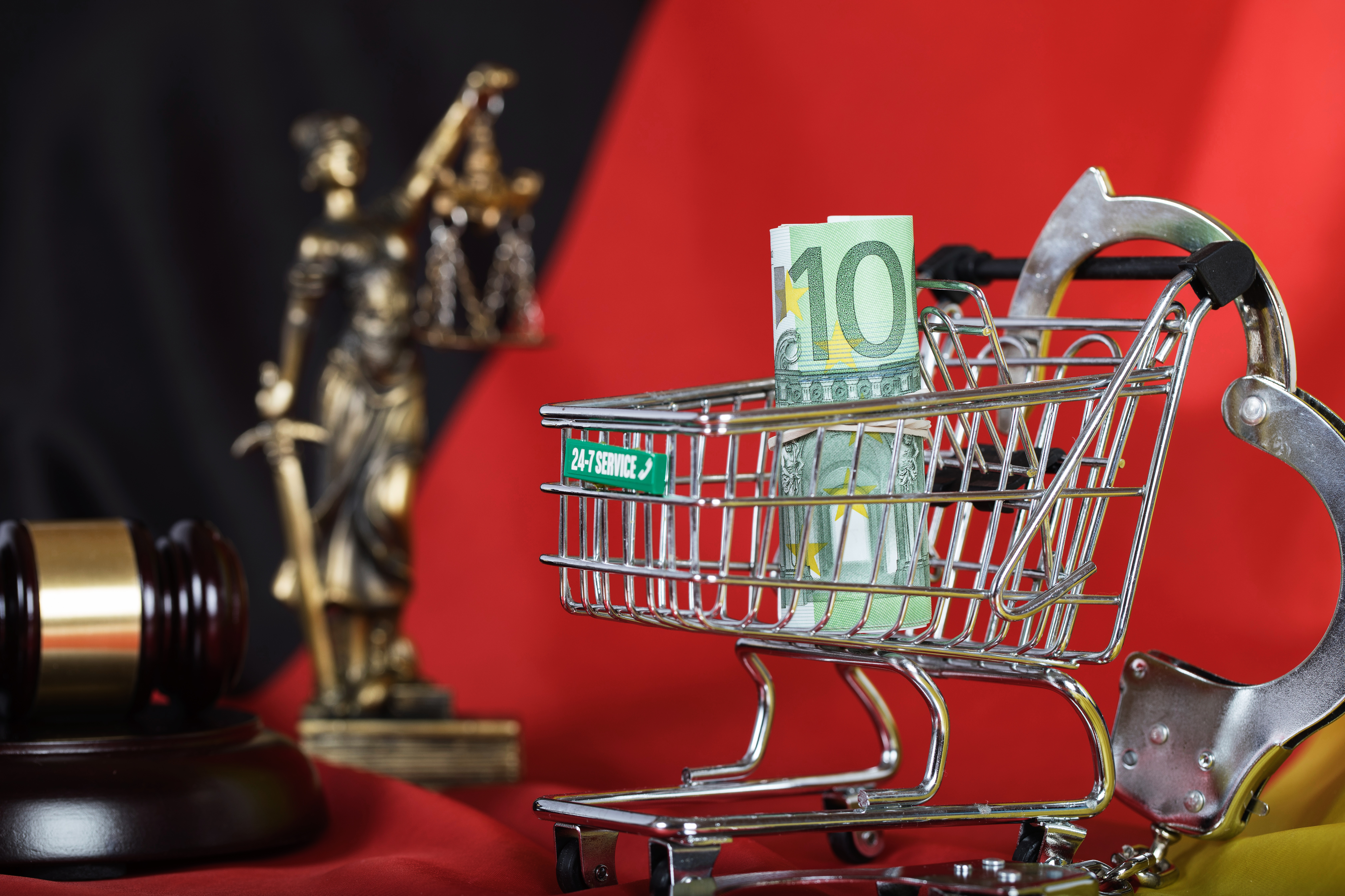 Euros in the shopping cart placed on a German flag. Closeup